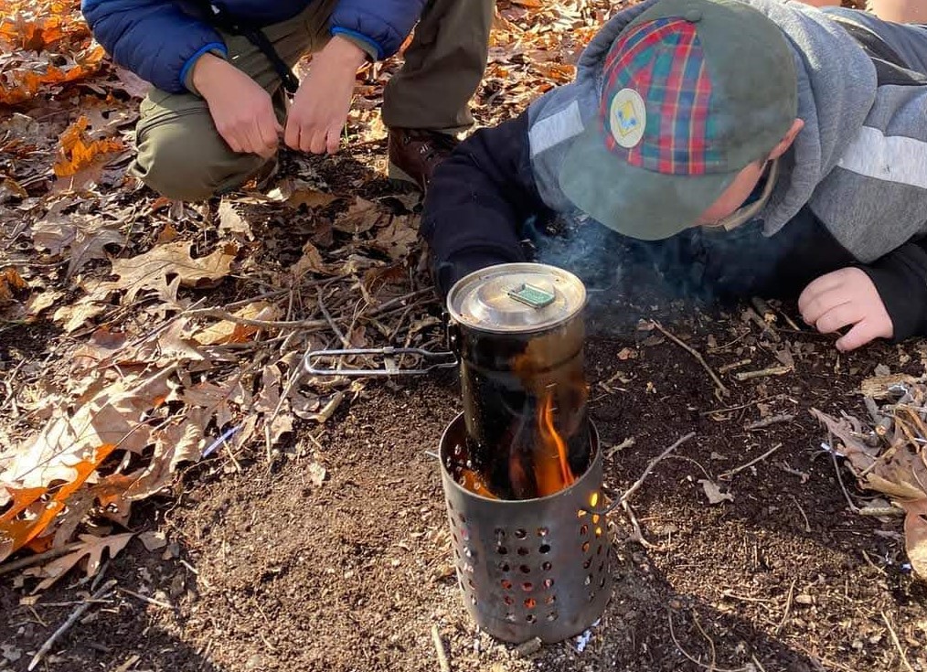 Racing to boil water for hot chocolate as part of the CastAway boy scout badge.